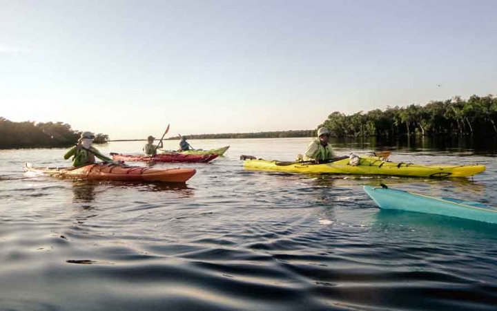 people in kayaks paddle on calm water on an outward bound course in florida